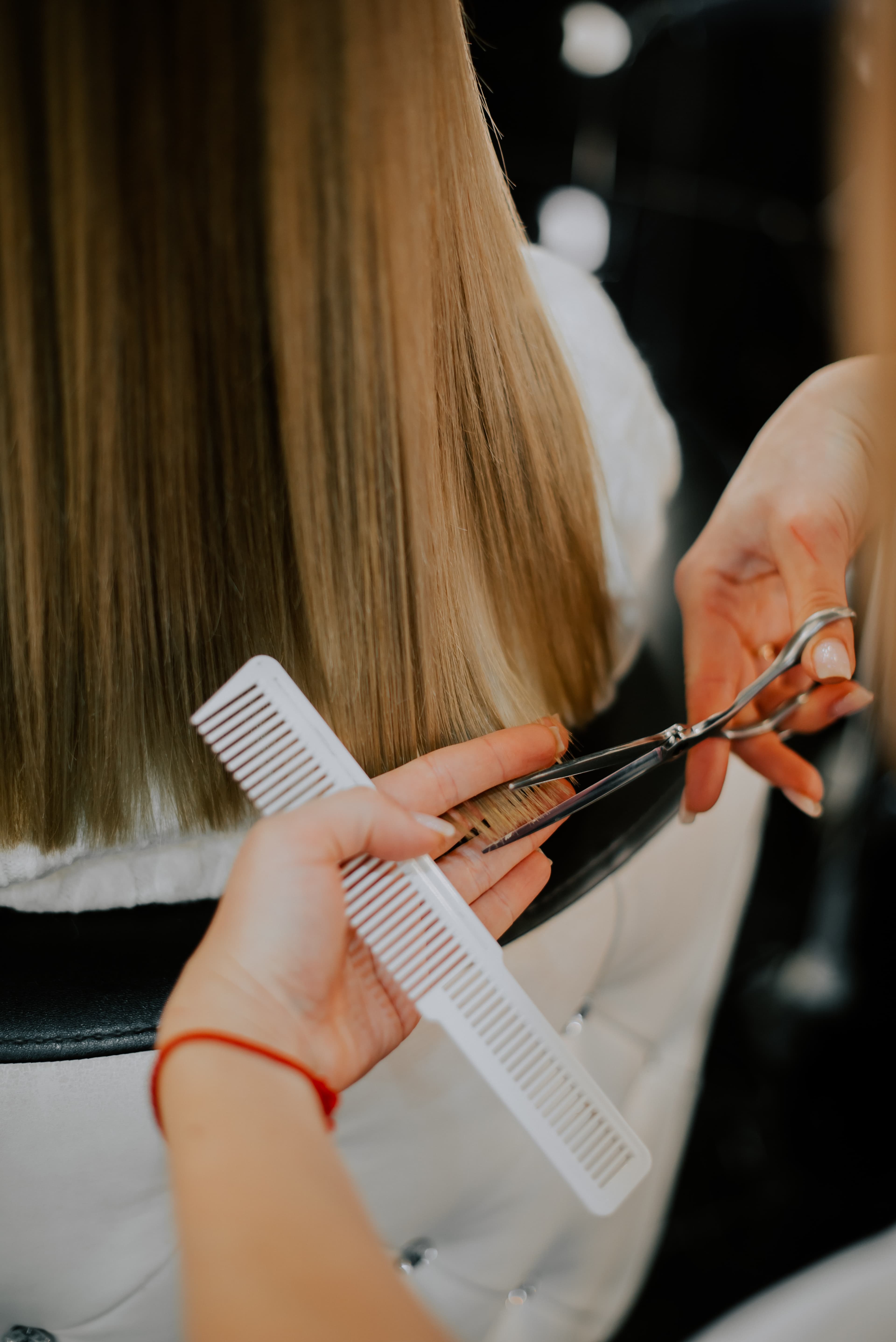 A stylist carefully cutting and styling a client's hair at Rebel & Rose